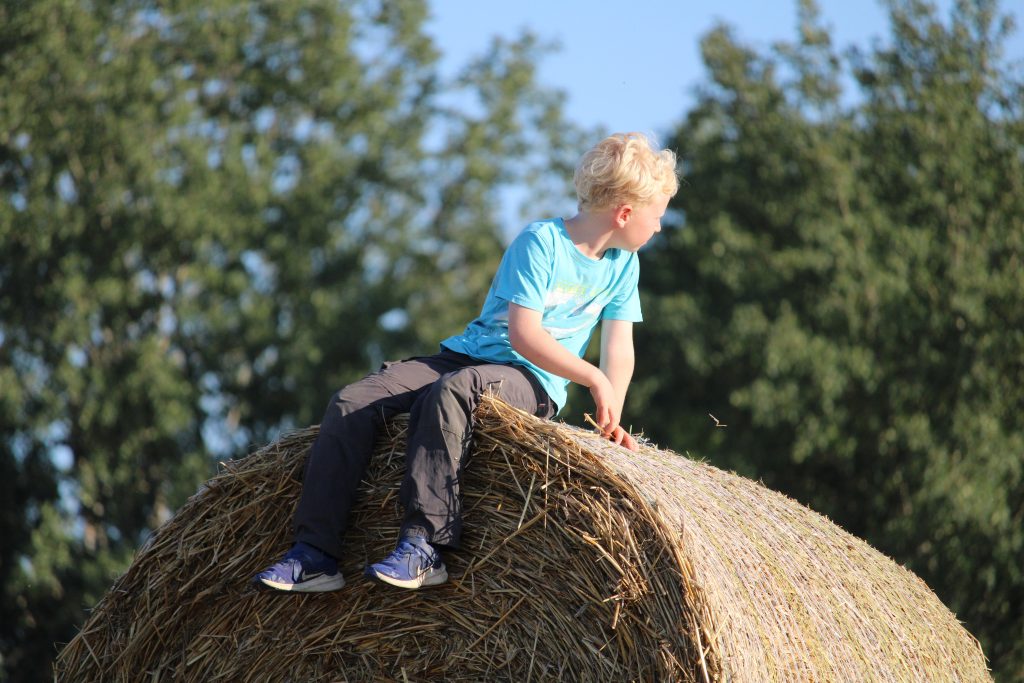 Kind auf Strohballen